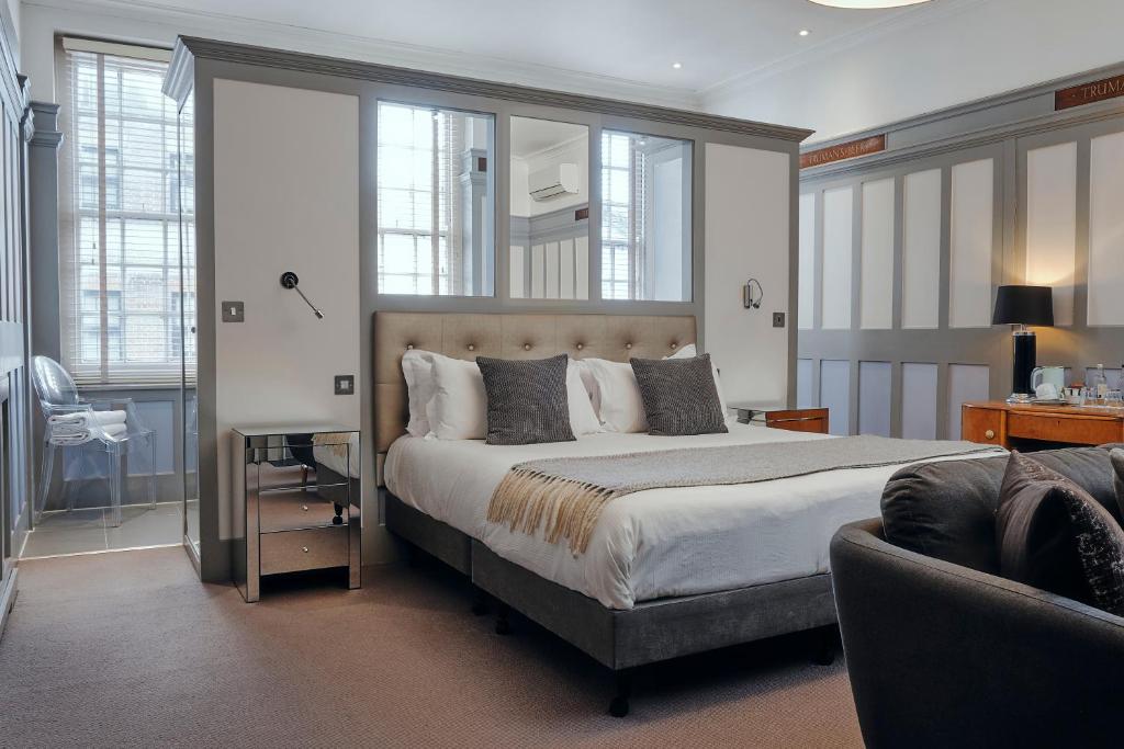a bedroom with a large bed and a couch at Rose and Crown Stoke Newington in London
