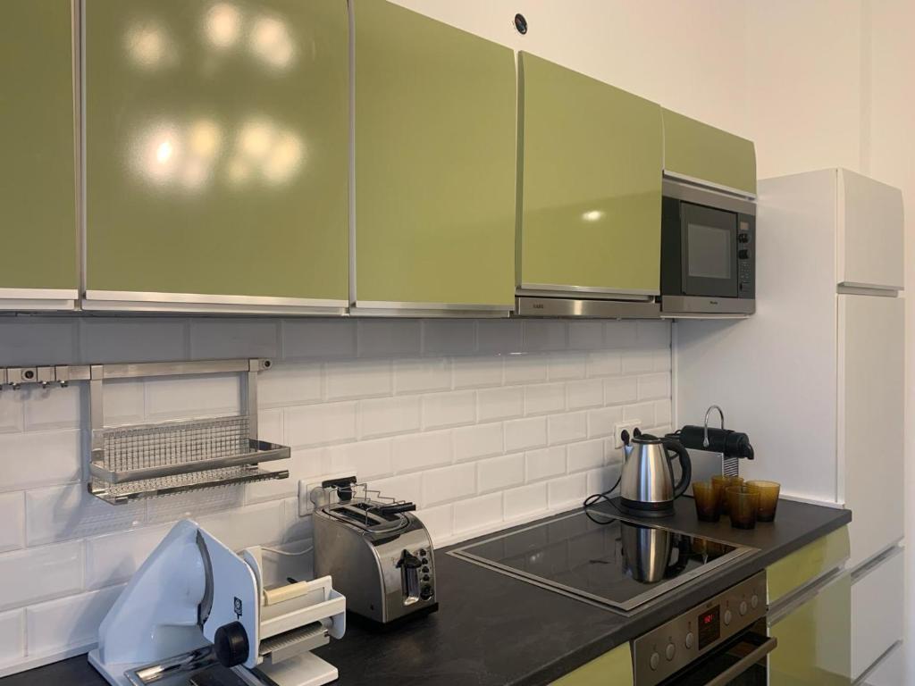 uma cozinha com armários verdes e uma bancada em sima Apartment em Essen