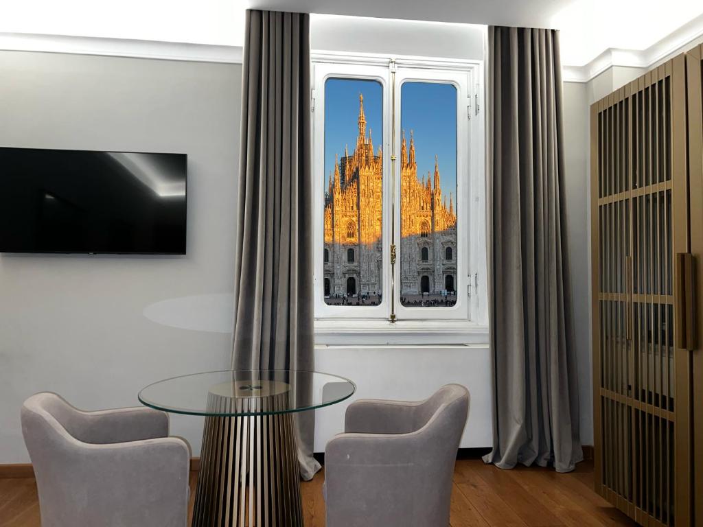 a dining room with a glass table in front of a window at SCF Collection - Duomo in Milan