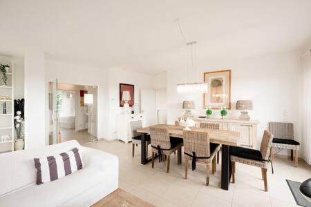 a white living room with a table and chairs at Luminous Penthouse with Open Sky Terrace in Sandweiler