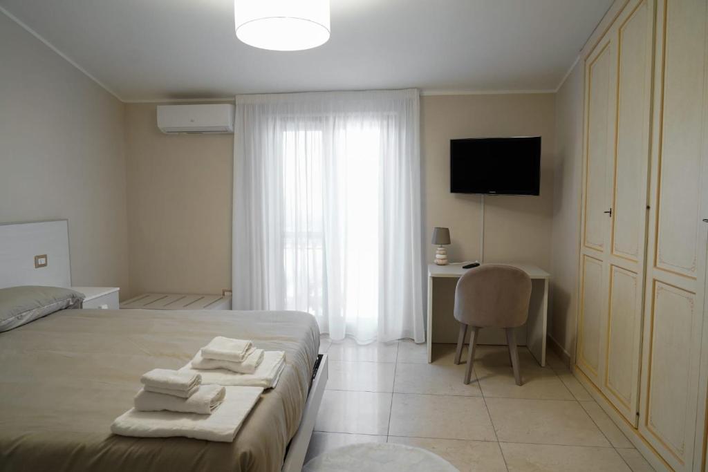 a bedroom with a bed and a desk and a television at Donna Filu Casa Vacanze in Santa Maria La Carità