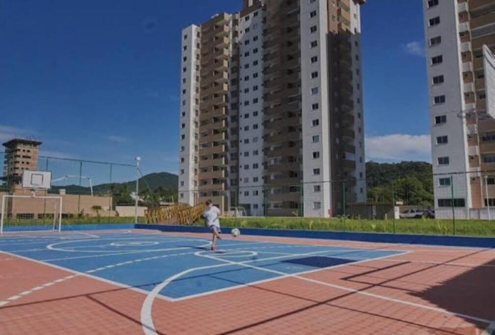 Een man speelt basketbal op een basketbalveld. bij Apartamento em Itapema- 10k de Balneário Camboriú in Itapema