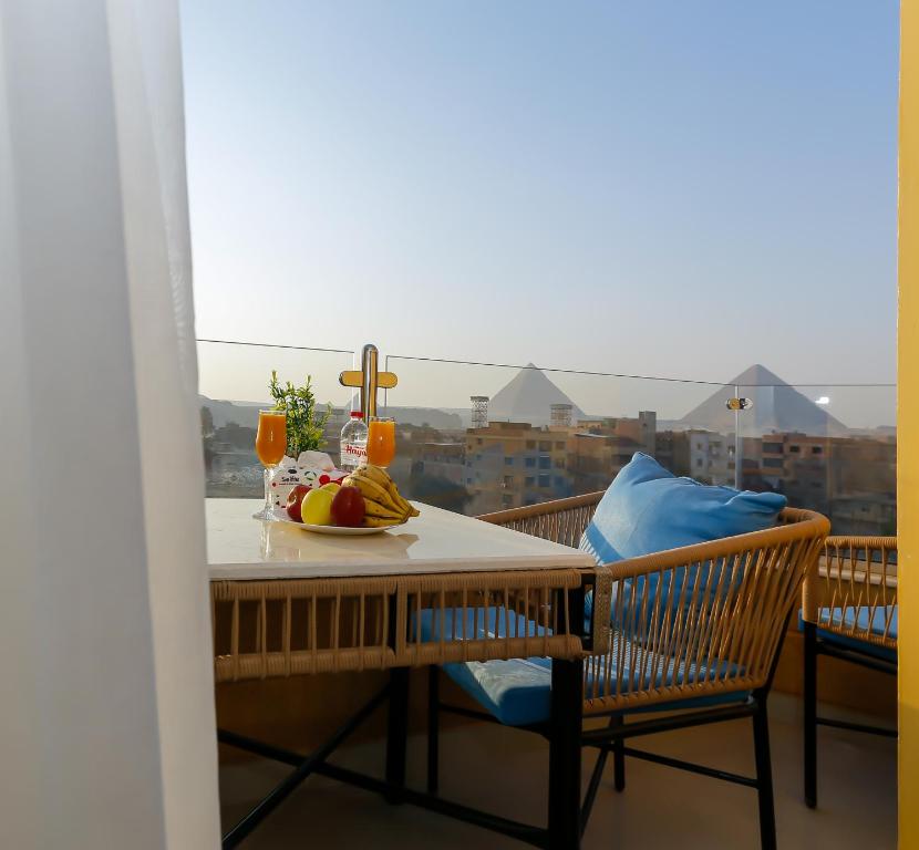 un tavolo con un piatto di frutta sul balcone di Diamond Pyramids View Inn a Il Cairo