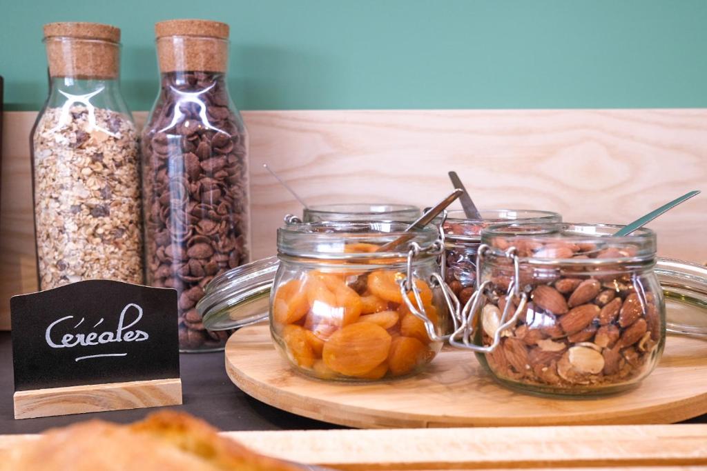 a table topped with jars of nuts and dried fruits at greet Hotel Belleville en Beaujolais A6 in Belleville-sur-Saône