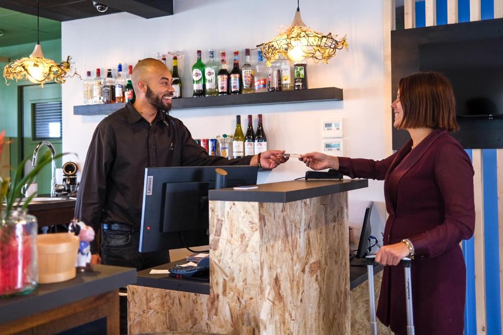 a man and a woman standing at a bar at greet Hotel Belleville en Beaujolais A6 in Belleville-sur-Saône