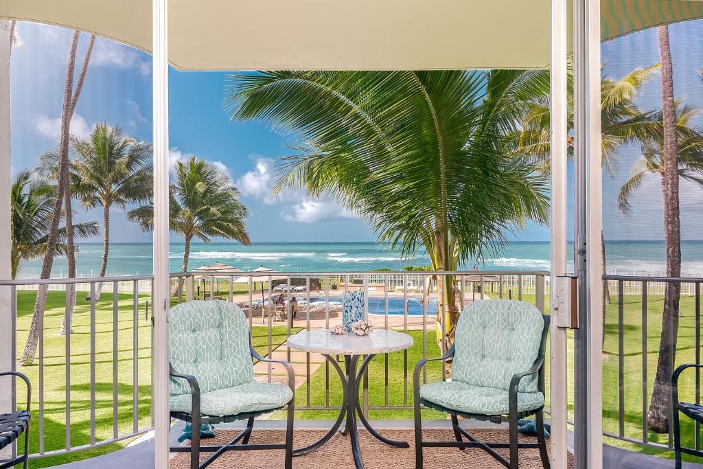 a balcony with a table and chairs and the beach at ***SERENDIPITY ON THE MOANA - Legal & Oceanfront - Great for Work & Play!*** in Waianae
