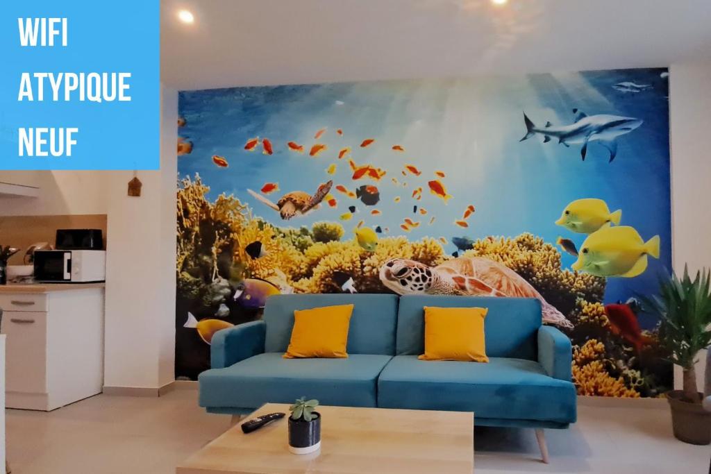 uma sala de estar com um sofá azul em frente a um aquário em L'Aquarium em Boulogne-sur-Mer