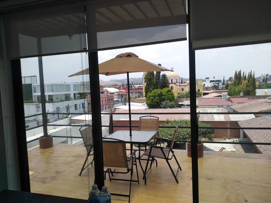 d'une table et de chaises sous un parasol sur le balcon. dans l'établissement Increíble PH en Cholula centro, Puebla, à Cholula