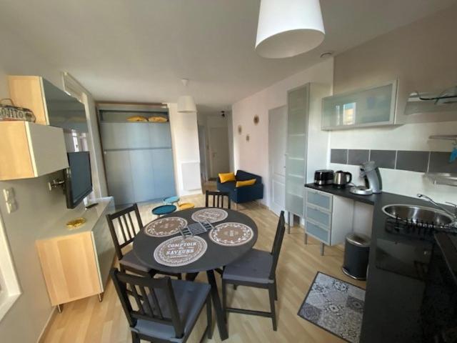 een keuken met een tafel en stoelen in een kamer bij NOUVEAU: Charmant appartement de 35m² in Mers-les-Bains