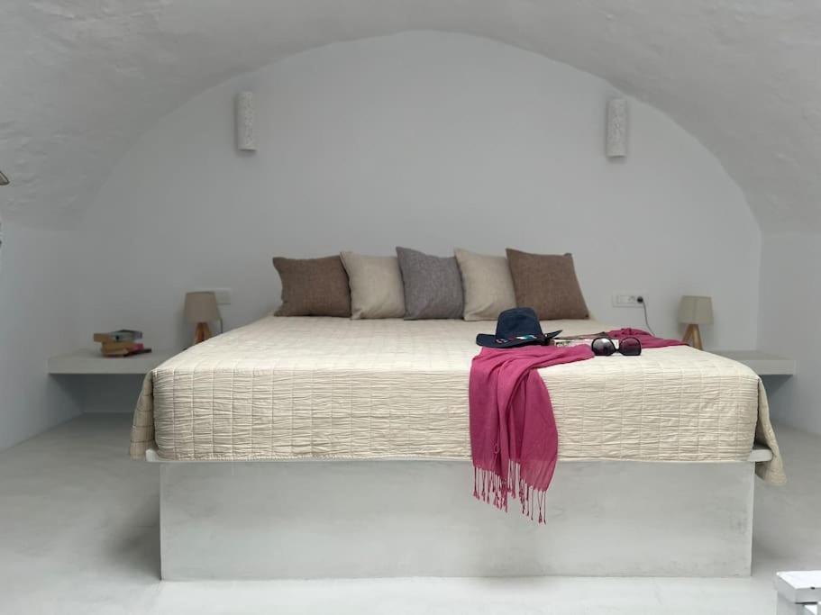 a bed with a pink blanket and a hat on it at Villa Family in Emporio