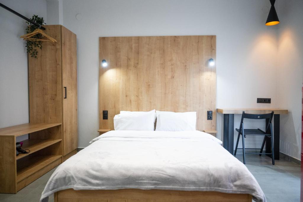 1 dormitorio con cama grande y cabecero de madera en THEMIS URBAN STAY en Komotini