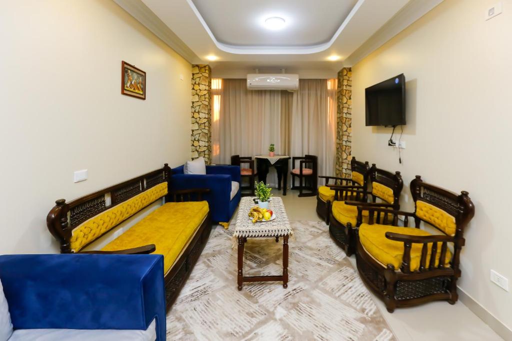 una camera con divani, tavolo e TV di Diamond Pyramids View Inn a Il Cairo