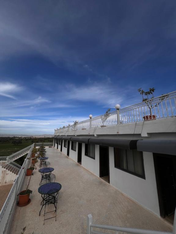 a balcony with chairs and tables on top of a building at Auberge Billionaire in Fez