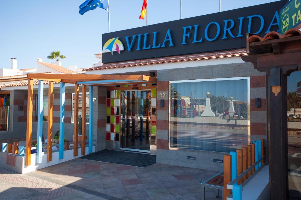 a building with a sign for allula florida at Apartamentos Villa Florida in Caleta De Fuste