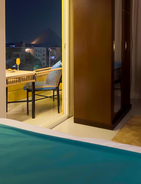 Camera dotata di balcone con sedia e finestra. di Diamond Pyramids View Inn a Il Cairo