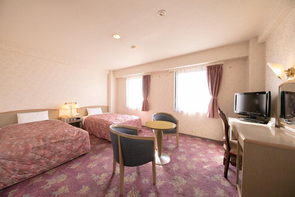 都城市にあるMain Hotel - Vacation STAY 85409vのベッド2台、デスク、テレビが備わるホテルルームです。