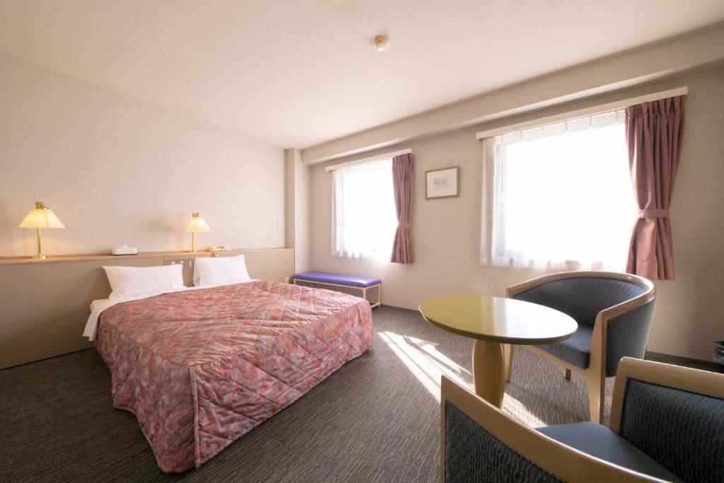 都城市にあるMain Hotel - Vacation STAY 85481vのベッド、テーブル、窓が備わる客室です。