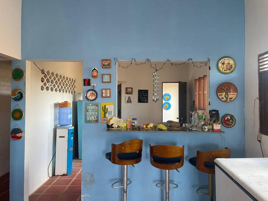 - une cuisine avec un comptoir et des tabourets dans une pièce dans l'établissement Casa de praia em Muriú, à Ceará-Mirim
