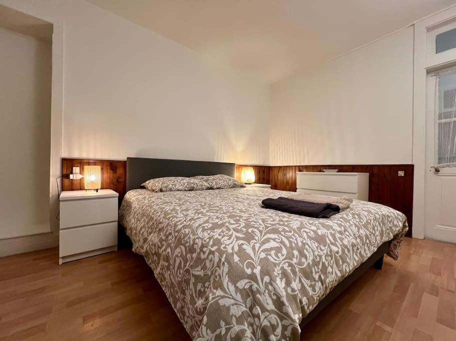 ein Schlafzimmer mit einem großen Bett und zwei Nachttischen in der Unterkunft La maison de Jean-Pierre  in Devecey