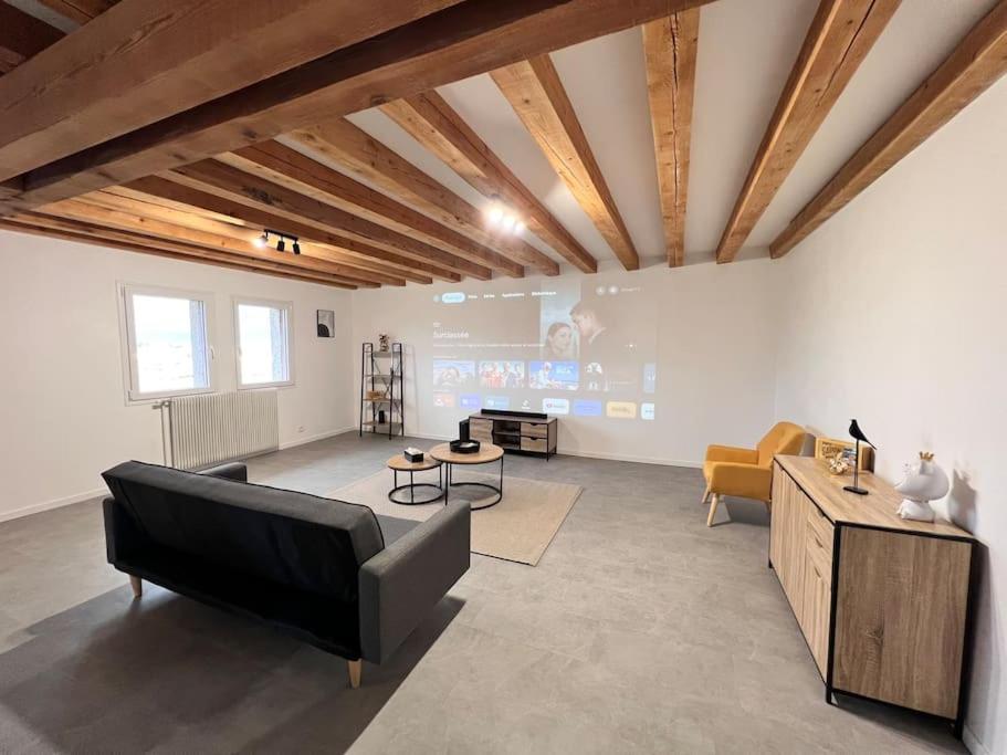 ein Wohnzimmer mit einem Sofa und einem Tisch in der Unterkunft Appartement au pied des Vignes in Vosne-Romanée