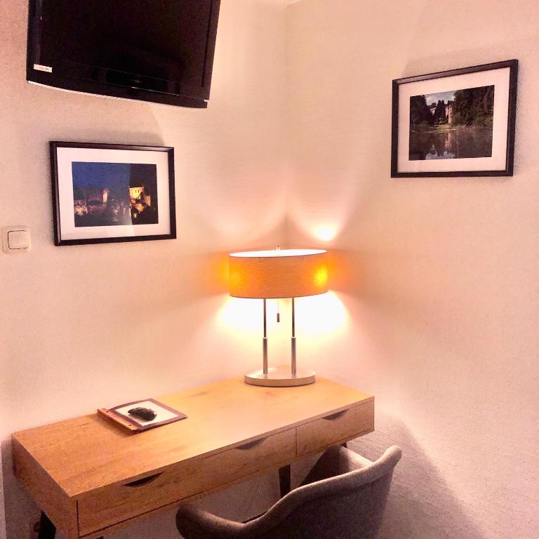 a table with a lamp on top of a wall at Hotel Auberge Rustique in Beaufort