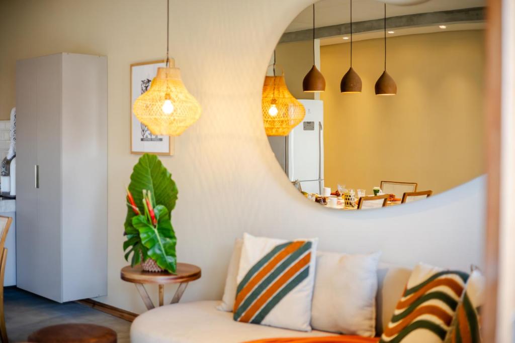 a living room with a couch and a mirror at Casa TUA no Preá pertinho do Mar in Cruz