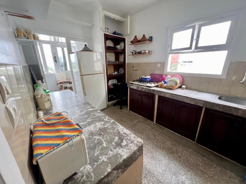 uma cozinha com uma bancada e um frigorífico em Appartement Lallaty em Rabat