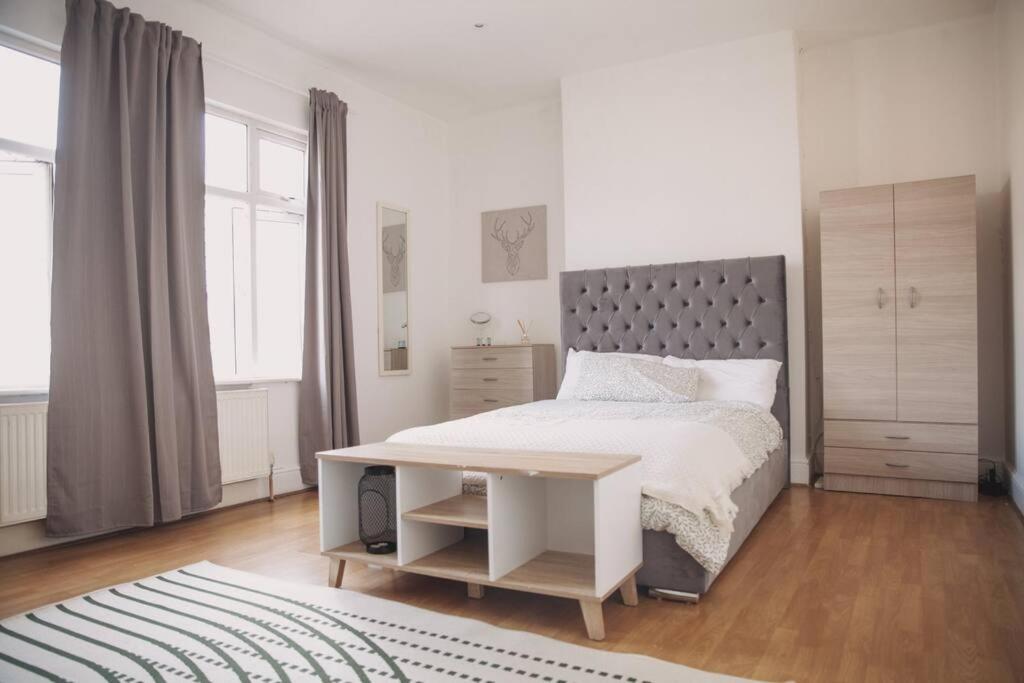 a white bedroom with a bed and a desk at 2 New bed flat in hammersmith in London