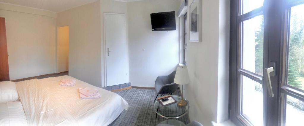 a hotel room with a bed and a window at Hotel Auberge Rustique in Beaufort
