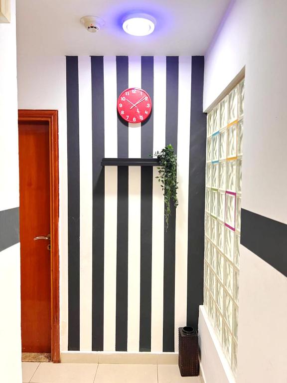 a room with a clock and a wall at Relaxing Closed Partition Room in Tecom Near Metro in Dubai
