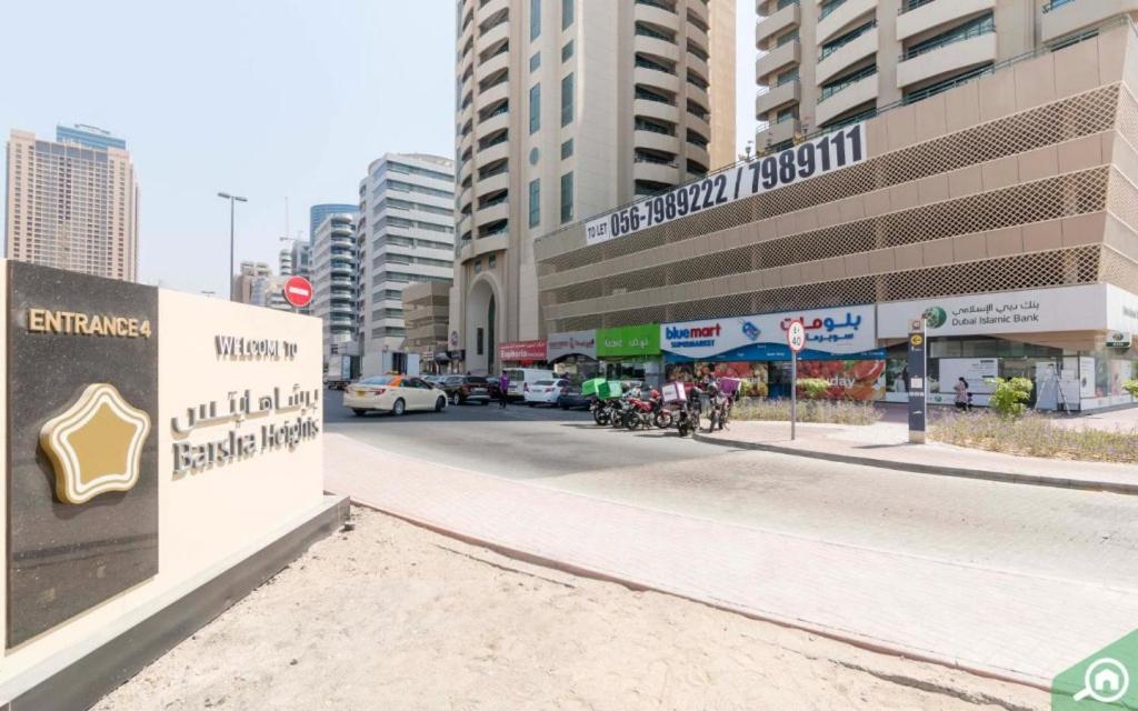 a street in a city with a sign and buildings at Relaxing Closed Partition Room in Tecom Near Metro in Dubai
