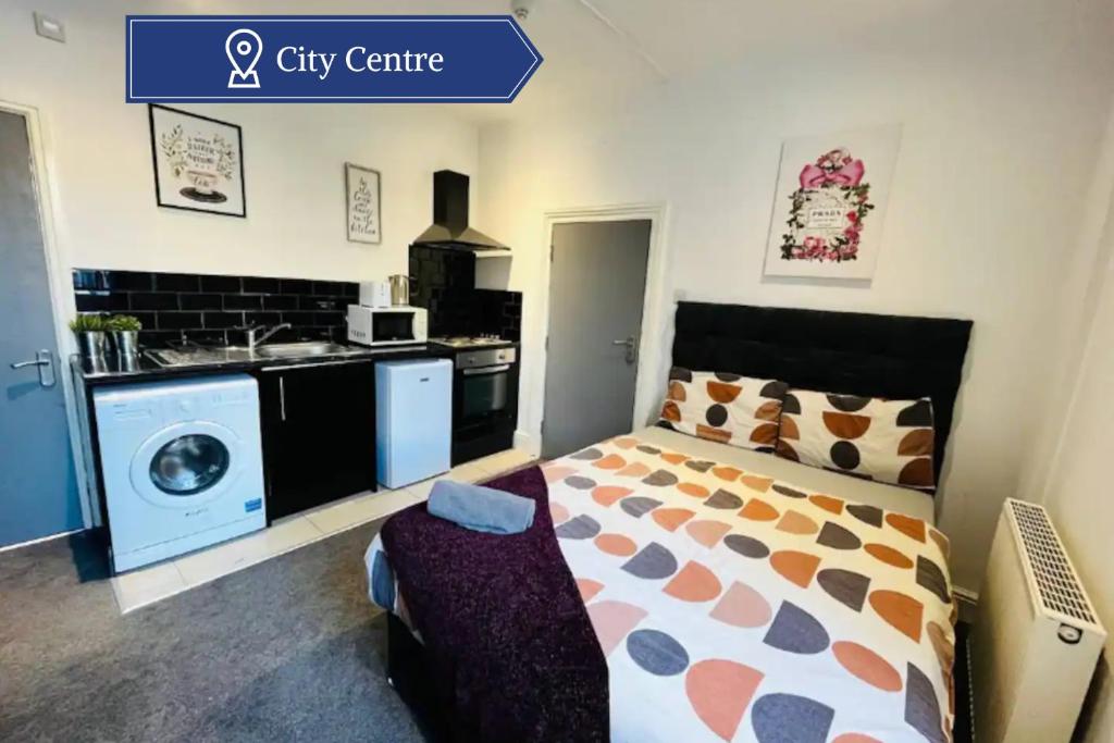 a small bedroom with a bed and a kitchen at City Hideout - Centrally Located Studio in Liverpool