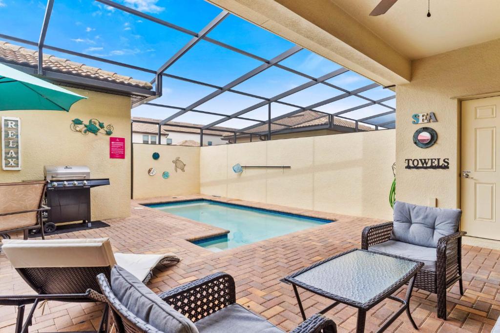 patio con tavolo e sedie e piscina. di Townhome with Private Pool, BBQ & FREE Waterpark a Kissimmee