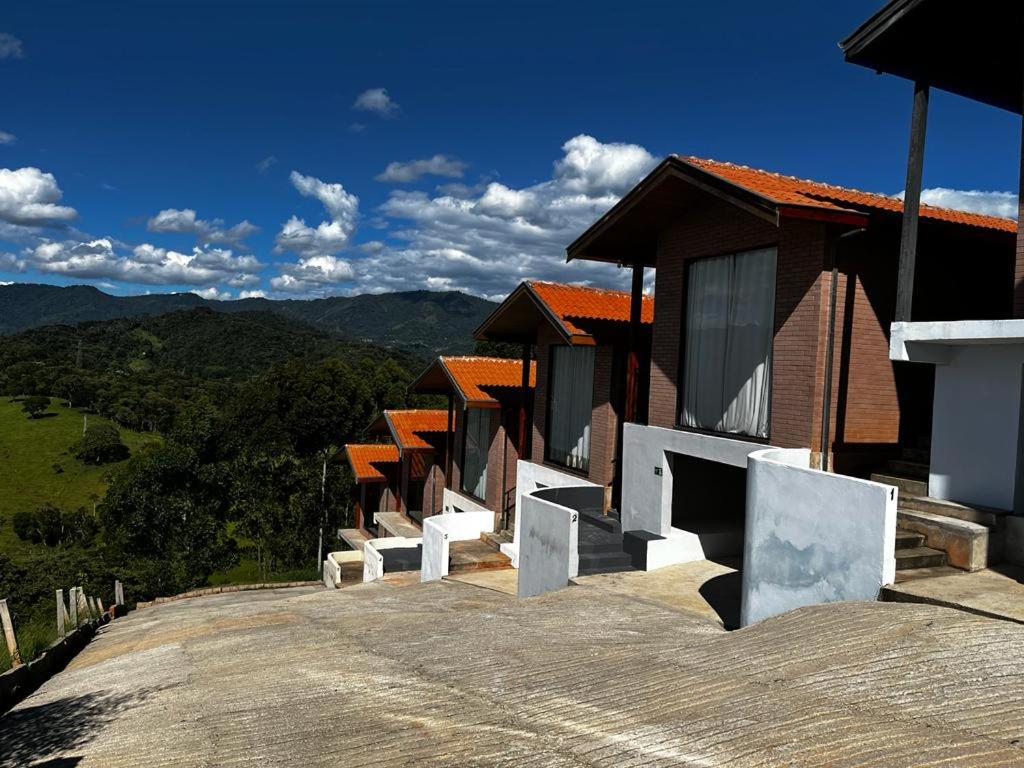 Une rangée de maisons sur le côté d'une route dans l'établissement Chalé Estância da Pinha seu Refúgio na Montanha, à Santo Antônio do Pinhal