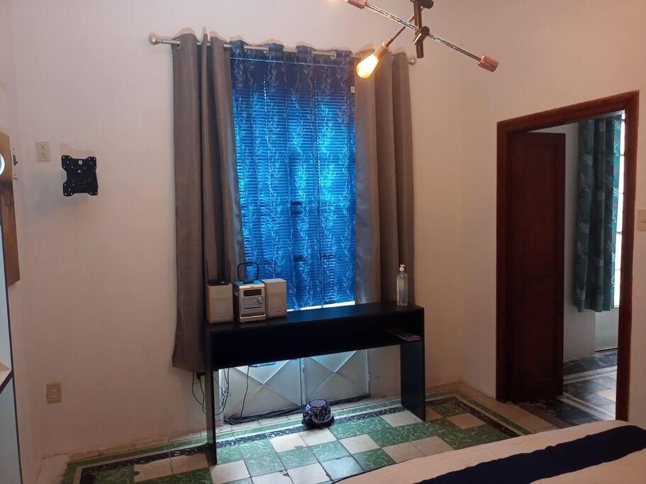 Zimmer mit einem Tisch und einem Fenster mit einer Mikrowelle in der Unterkunft Casa Amparo, A media calle del zócalo Centro in Puebla