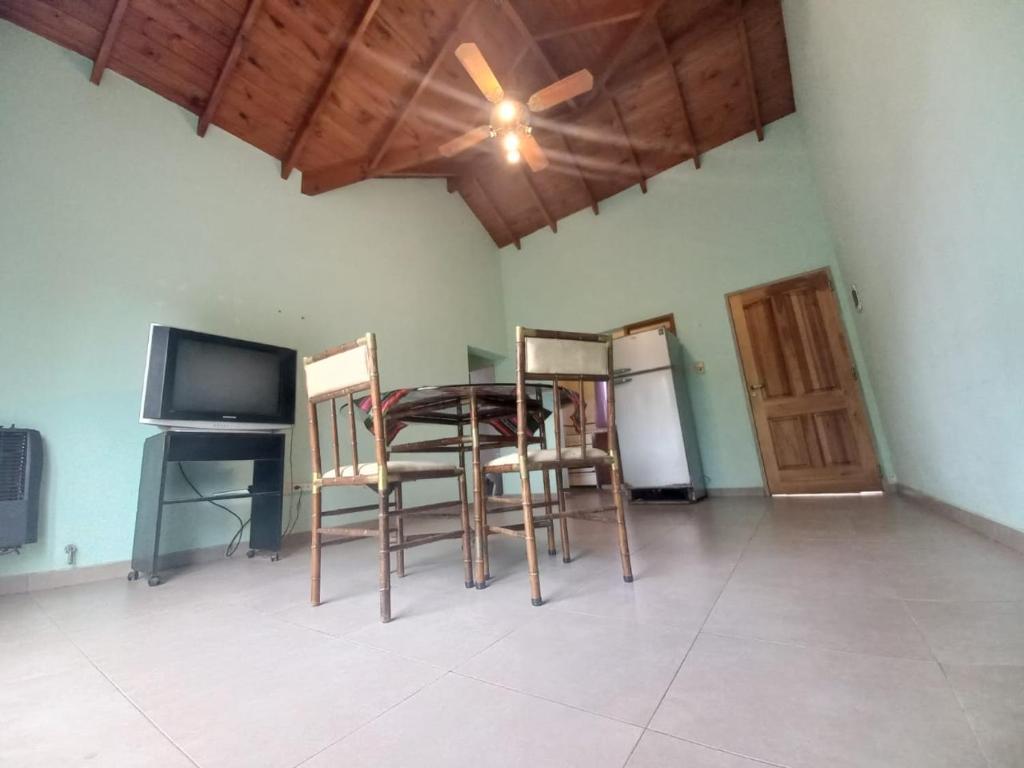 a kitchen with a table and chairs and a refrigerator at Tantanakuy 2 in Villa General Belgrano