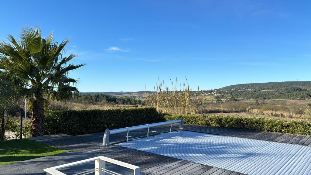 eine Terrasse mit einem Tisch und einer Palme in der Unterkunft Villa Maïa in Saint-Gély-du-Fesc
