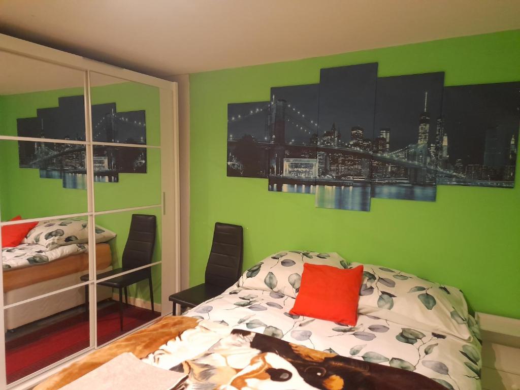 um quarto com paredes verdes e uma cama com uma almofada vermelha em Bastolino em Newtongrange