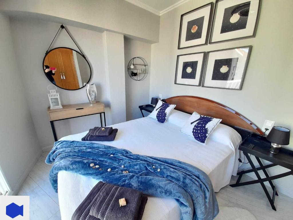 a bedroom with a bed and a desk and a mirror at Apartamento de Pescado Azul Gandia playa con piscina ascensor y vistas al mar in Playa de Gandia