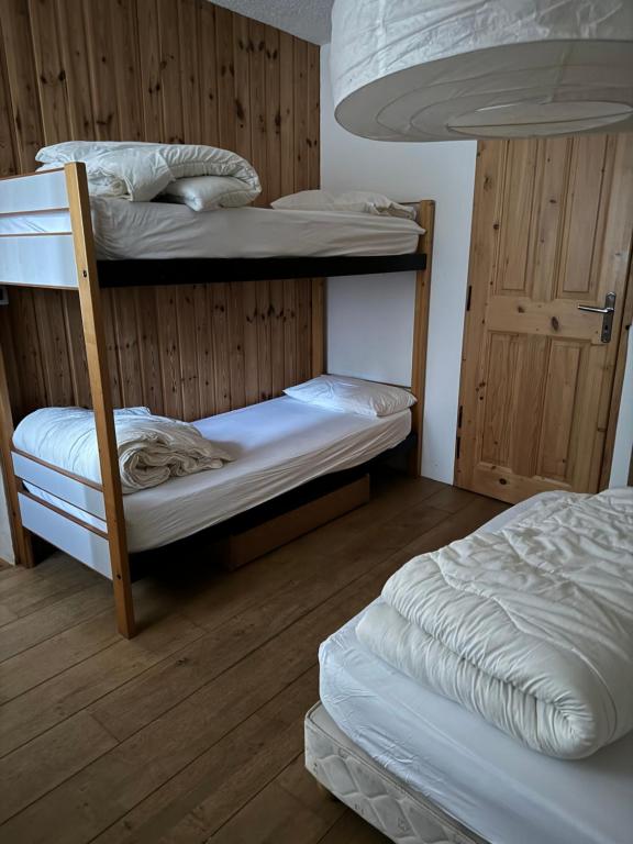 a room with two bunk beds and a door at Le Bouffadou in Peisey-Nancroix