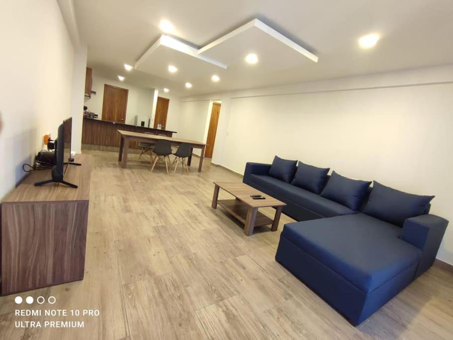 - un salon avec un canapé bleu et une table dans l'établissement Espectacular depa en Cholula, puebla 103 A, à Cholula