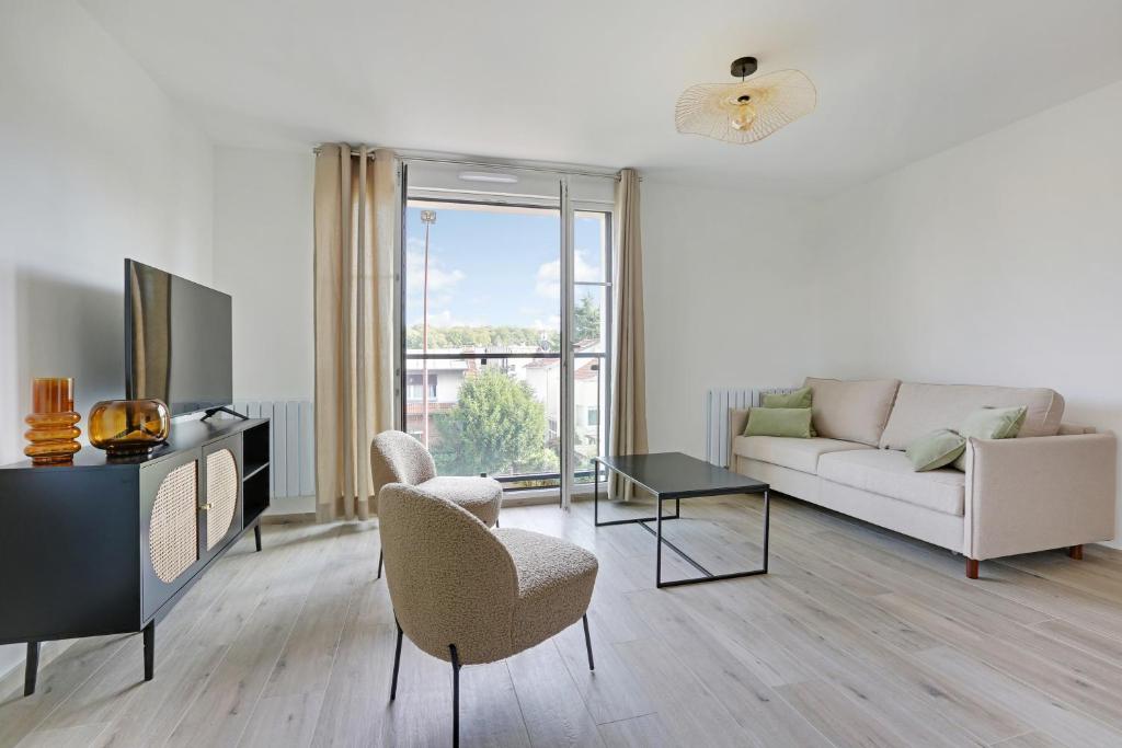 een woonkamer met een bank en stoelen en een tv bij La Résidence Alpha Viroflay 201 - 1 chambre - 4 pers in Viroflay