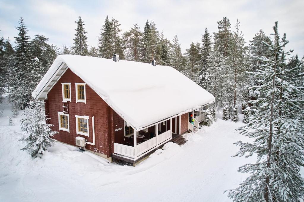 a house covered in snow in the woods at Villa Peippo in Rovaniemi