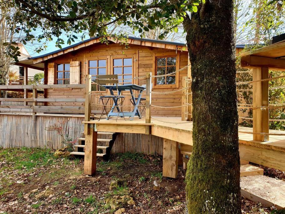 une cabane en rondins avec une table et un arbre dans l'établissement Nuit d'Amour - Chalet cocooningchauffé/climatisé, à Carsac-Aillac