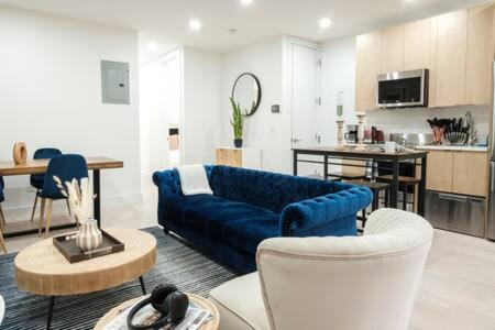 a living room with a blue couch and a kitchen at 3BR 2Baths with Private Outdoors in New York