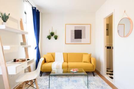 a living room with a yellow couch and a table at Renovated 1br in East Village in New York