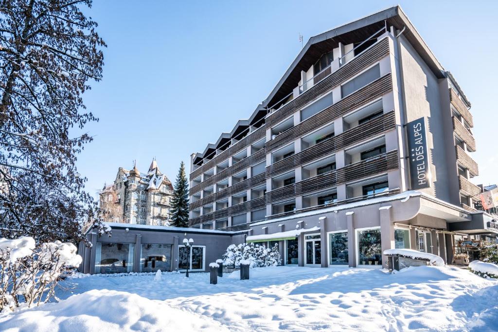 a building in the snow with snow covered grounds at Studio im Hotel Des Alpes in Flims