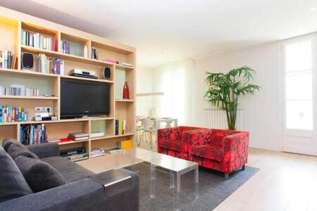 a living room with a couch and a red chair at Classy 3bed 3bath apartment in Eixample in Barcelona