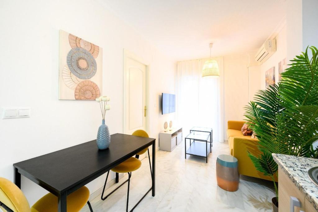 a living room with a black table and yellow chairs at Capitan, 1 bedromm, city center & beach by 10TSea in Fuengirola