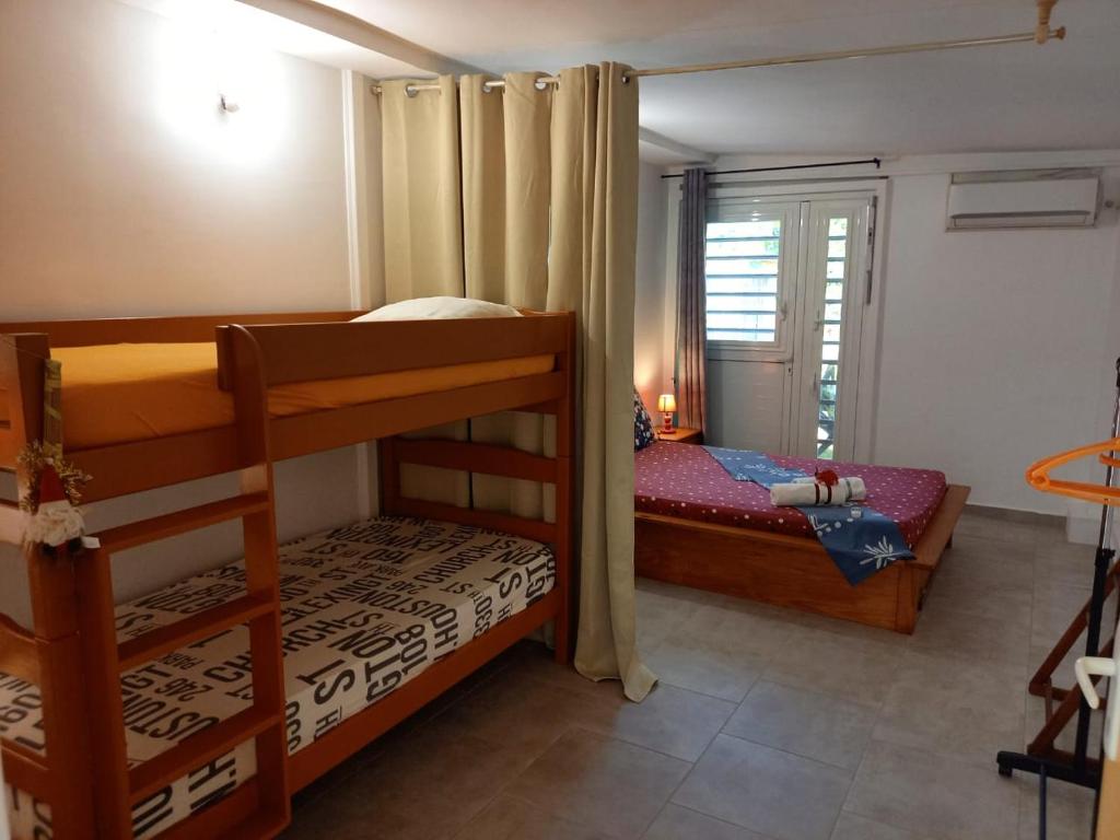 a bedroom with two bunk beds and a window at Fetay Jaune in Baie-Mahault